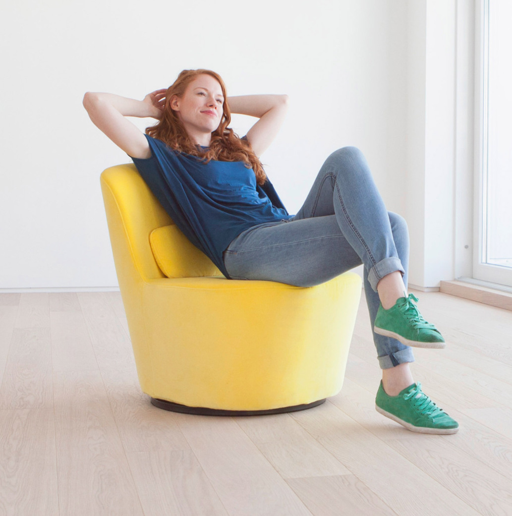 Woman sitting on a coach in a relaxed position.