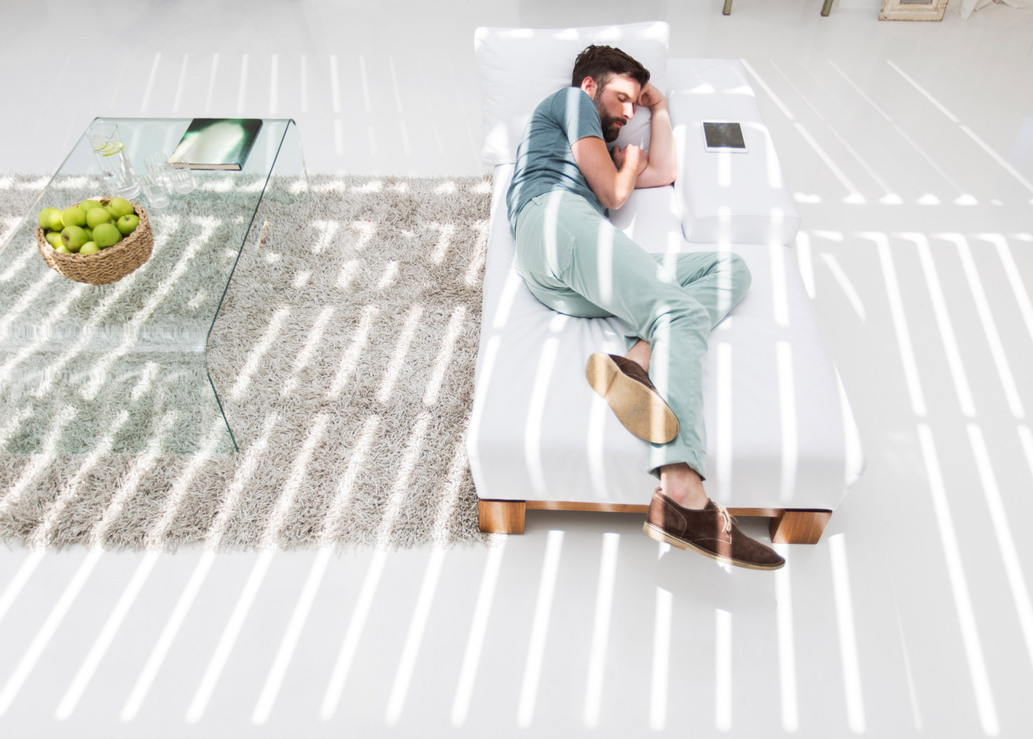 Man resting relaxed on a bed.