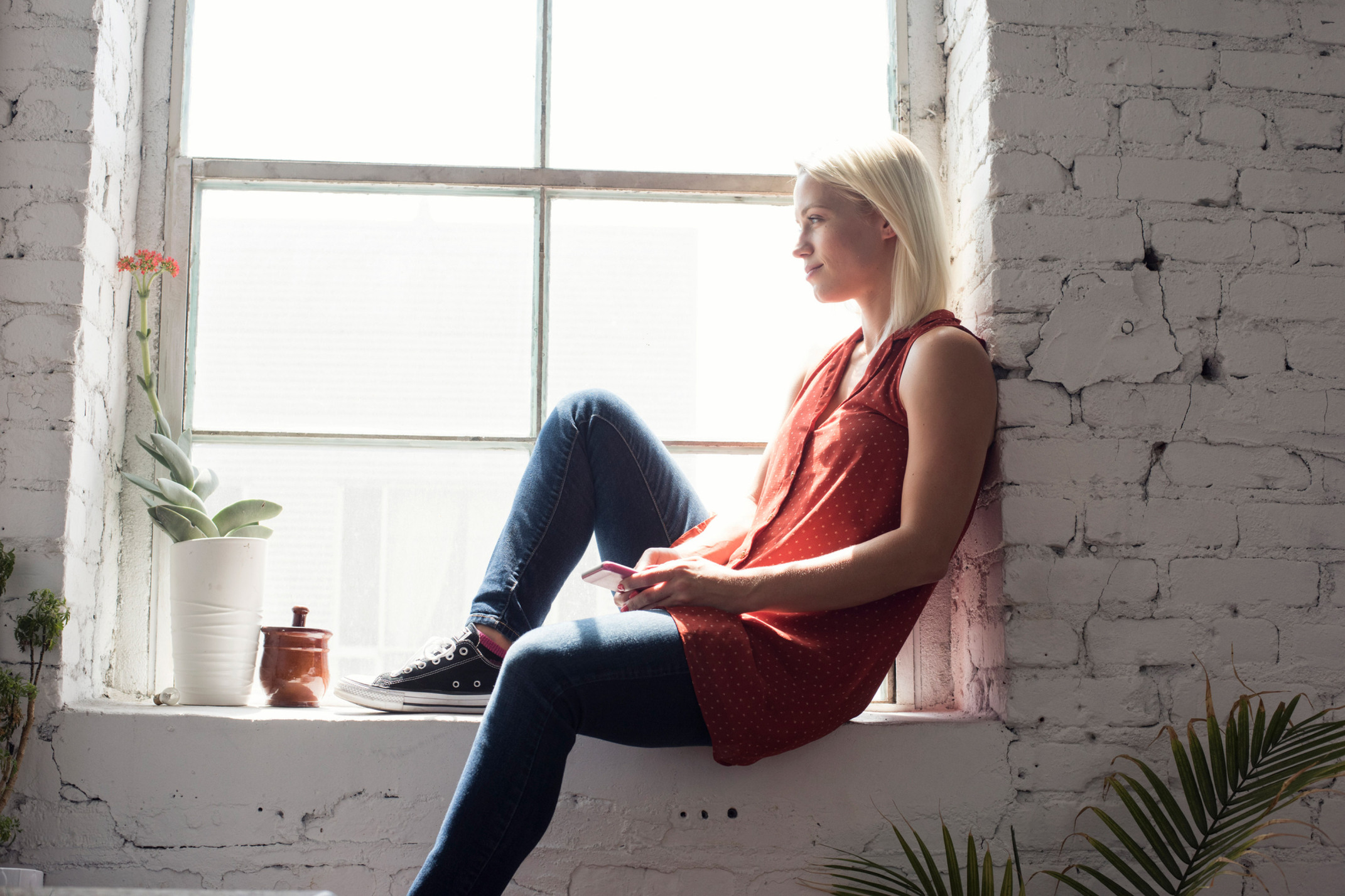 Blonde woman looking through the window.